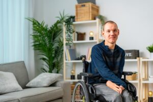 Portrait,Of,A,Cheerful,Disabled,Man,In,Wheelchair,Smiling,At