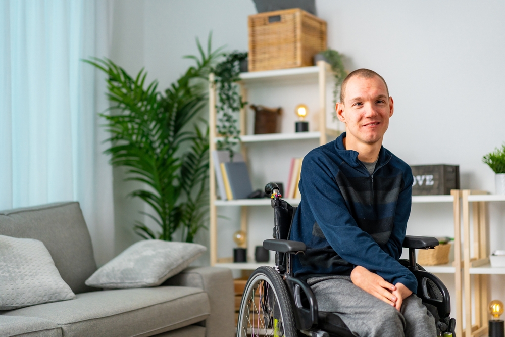 Portrait,Of,A,Cheerful,Disabled,Man,In,Wheelchair,Smiling,At