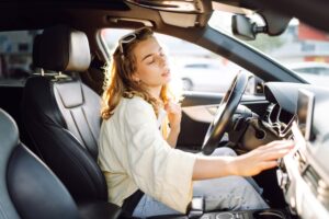Woman,Sits,Behind,Wheel,Of,Car,,Placing,Hand,On,Forehead,