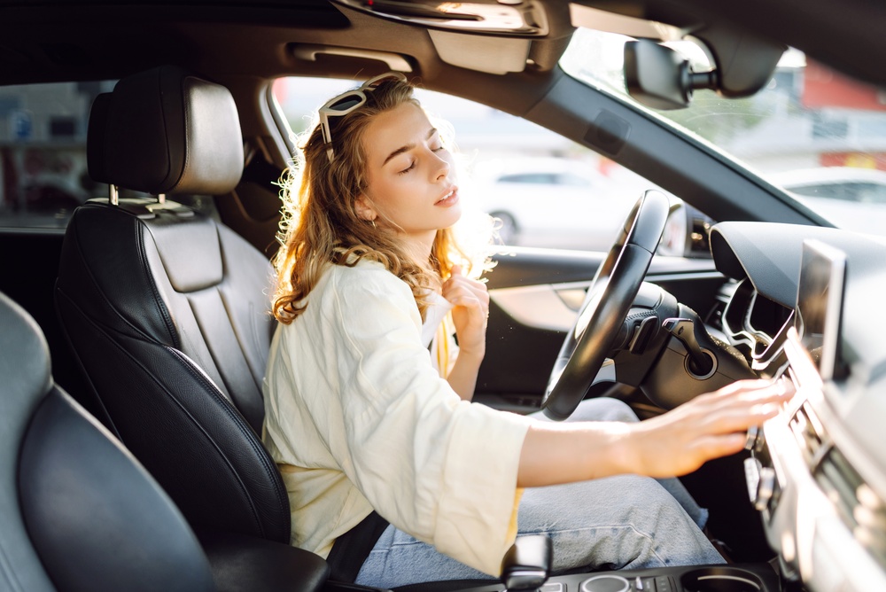 Woman,Sits,Behind,Wheel,Of,Car,,Placing,Hand,On,Forehead,